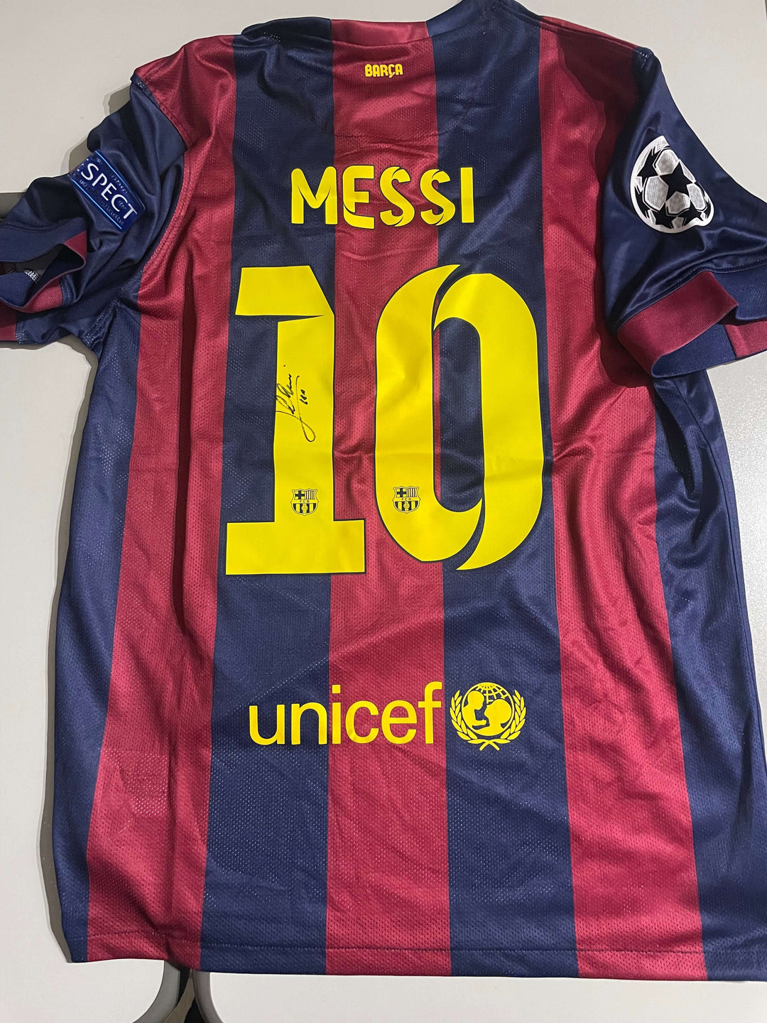 Lionel Messi signed 2015 Champions League final jersey featuring number 10 and UNICEF logo, showcasing his iconic style.